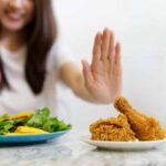 Woman with junk food and a salad