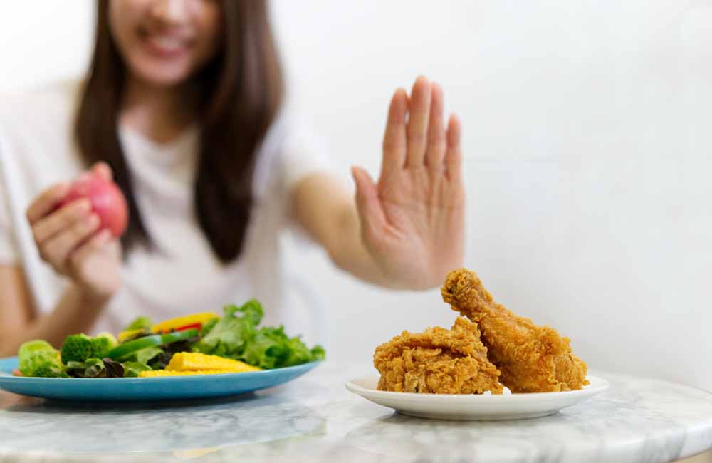 Woman with junk food and a salad