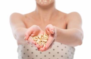 Woman with oatmeal facial mask & showing oatmeal